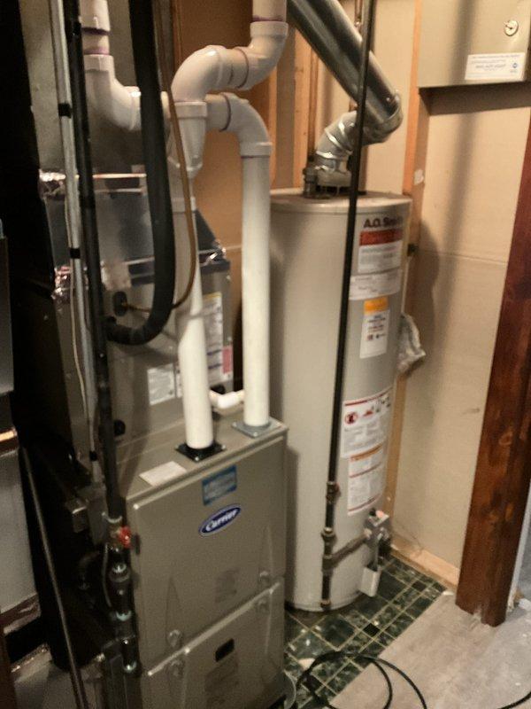 Completed free estimate for water heater replacement at residential property. Assessed existing 15-year-old tank-style water heater located in basement utility area alongside Carrier furnace system. Documented current installation configuration including copper supply piping, PVC venting arrangement, and proximity to existing HVAC equipment. Photographed equipment specifications, manufacturer labels, clearance requirements, and surrounding infrastructure to prepare replacement recommendations and accurate proposal for customer.