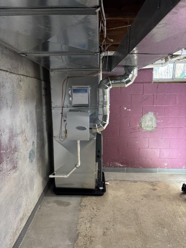 Removed existing furnace unit and completed full installation of new gray furnace system in basement utility area. Installed and configured all associated ductwork including metal supply and return ducts, connected white PVC venting pipes for exhaust and intake, and attached black flexible ducting to air handler. Verified all connections, tested system operation, and confirmed proper airflow throughout the HVAC distribution system.