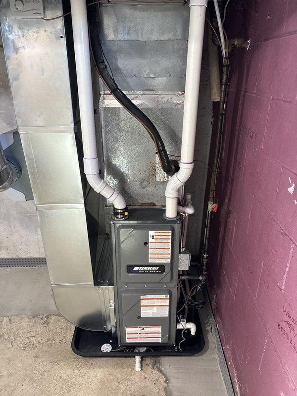 Removed existing furnace unit and completed full installation of new gray furnace system in basement utility area. Installed and configured all associated ductwork including metal supply and return ducts, connected white PVC venting pipes for exhaust and intake, and attached black flexible ducting to air handler. Verified all connections, tested system operation, and confirmed proper airflow throughout the HVAC distribution system.