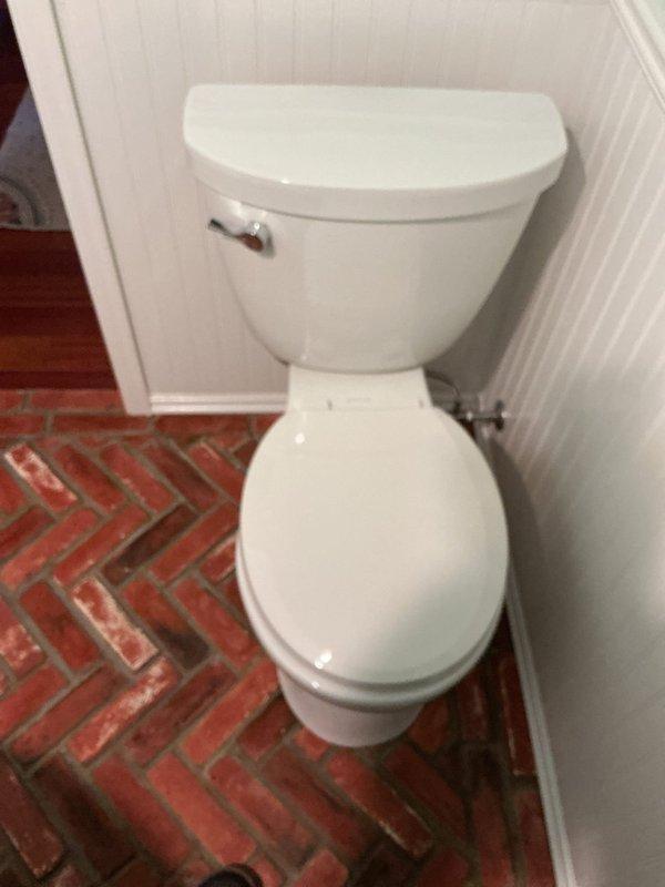 Completed installation of new toilet in powder room featuring herringbone brick flooring and beadboard wainscoting. Removed existing fixture, installed new two-piece porcelain toilet with chrome flush lever and water supply line, ensuring proper sealing and connection to existing plumbing. All work completed as quoted with customer satisfaction confirmed.
