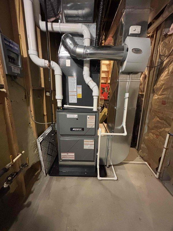 Removed and replaced the existing furnace and air conditioning system, installing a new gas furnace with matched evaporator coil in the basement and a new outdoor condenser on a level concrete pad. Connected refrigerant lines, condensate drain piping, PVC combustion venting, ductwork, and the electrical disconnect, and reconnected the whole-house humidifier. System was verified clean and intact with no visible damage, and financing paperwork was completed and activated.