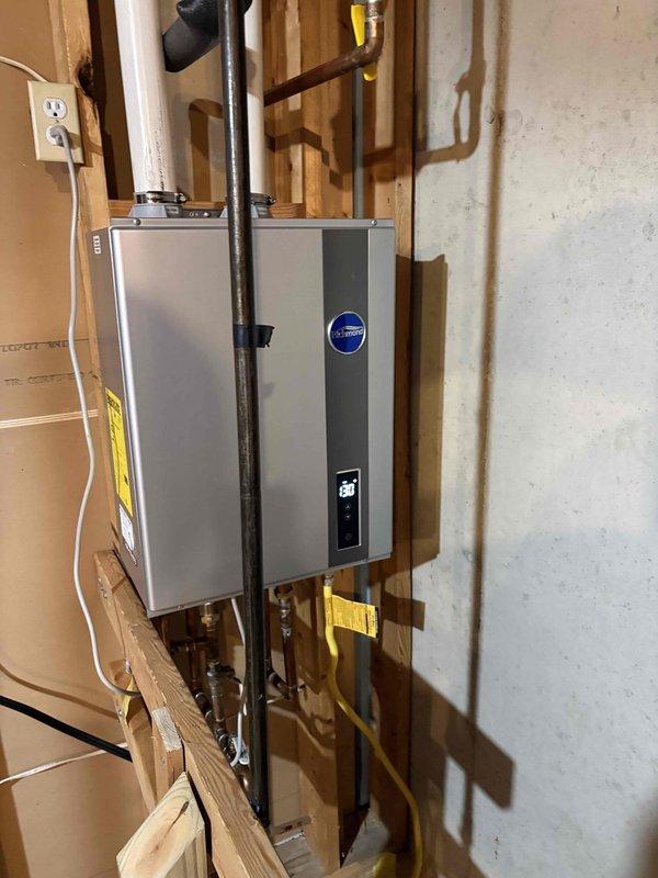 Diagnosed a no-heat condition on a Richmond tankless water heater (approximately 2 years old) and traced the fault to a failed combustion blower motor. Replaced the blower motor, verified proper venting and gas connections, and cycled the unit to confirm normal ignition, stable operation, and correct outlet temperature output at the display.