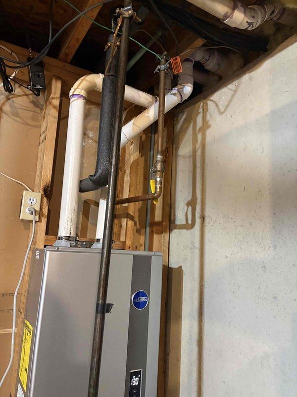 Diagnosed a no-heat condition on a Richmond tankless water heater (approximately 2 years old) and traced the fault to a failed combustion blower motor. Replaced the blower motor, verified proper venting and gas connections, and cycled the unit to confirm normal ignition, stable operation, and correct outlet temperature output at the display.