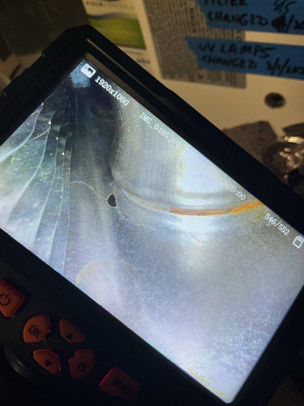 Performed annual heating inspection on a 16-year-old furnace, including borescope examination of the heat exchanger. Imaging revealed a perforation with an associated hairline crack and rust streaking along the seam, indicating heat exchanger failure. Documented findings with photos and recommended heat exchanger or furnace replacement, as continued operation poses a carbon monoxide safety risk.