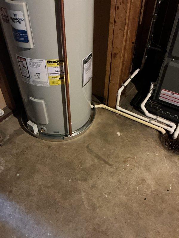 Installed a new 50-gallon tall electric Bradford White water heater in a drain pan, with copper supply connections, a drain valve, and a temperature and pressure relief discharge line routed to the floor drain. Verified connections are secure with no visible leaks, and the unit is properly positioned and ready for operation.