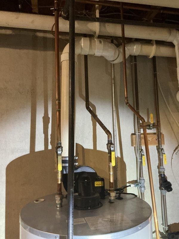 Performed an on-site estimate for replacement of an approximately 12-year-old gas-fired power-vent water heater. Inspected the unit, its PVC power-vent assembly, gas supply and control valve, and copper supply lines with isolation ball valves, and documented existing conditions with photographs. Observed no visible leaks, corrosion, or damage to the tank or piping, and assessed the installation for replacement scope and options.