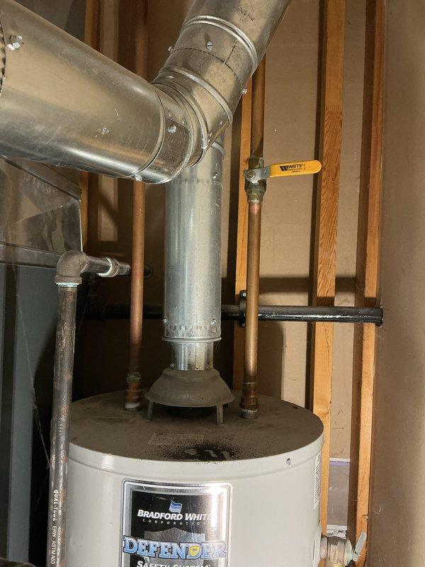 Evaluated a 40-gallon gas-fired water heater with a failed, corroded tank leaking onto the floor and documented the existing installation, including the galvanized draft hood and flue venting, copper supply lines with shutoff valve, and corroded iron gas piping. Prepared a replacement estimate for the unit, with the customer requesting expedited installation.