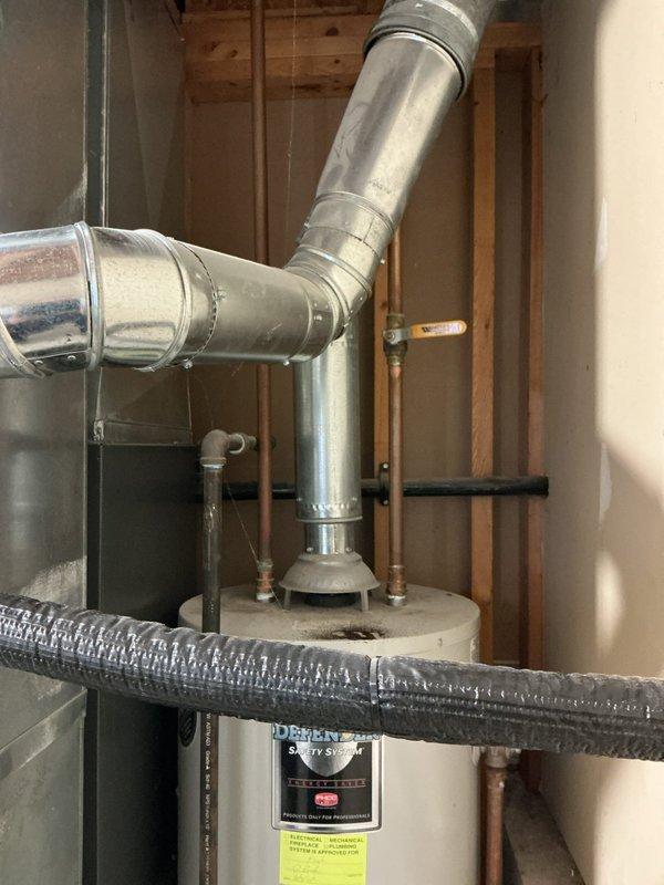 Evaluated a 40-gallon gas-fired water heater with a failed, corroded tank leaking onto the floor and documented the existing installation, including the galvanized draft hood and flue venting, copper supply lines with shutoff valve, and corroded iron gas piping. Prepared a replacement estimate for the unit, with the customer requesting expedited installation.