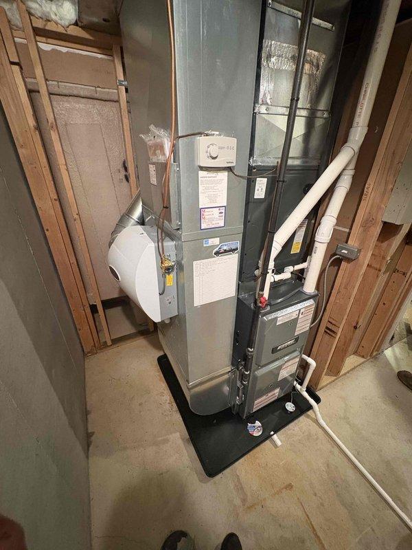Installed a new Amana Elite Series upflow gas furnace on a drip pan, connecting it to the existing supply plenum and ductwork. Completed PVC combustion air/exhaust venting, condensate drain line, gas piping with shutoff, and electrical connections. Reinstalled the humidifier and thermostat control, and applied all required warning and instruction labels.