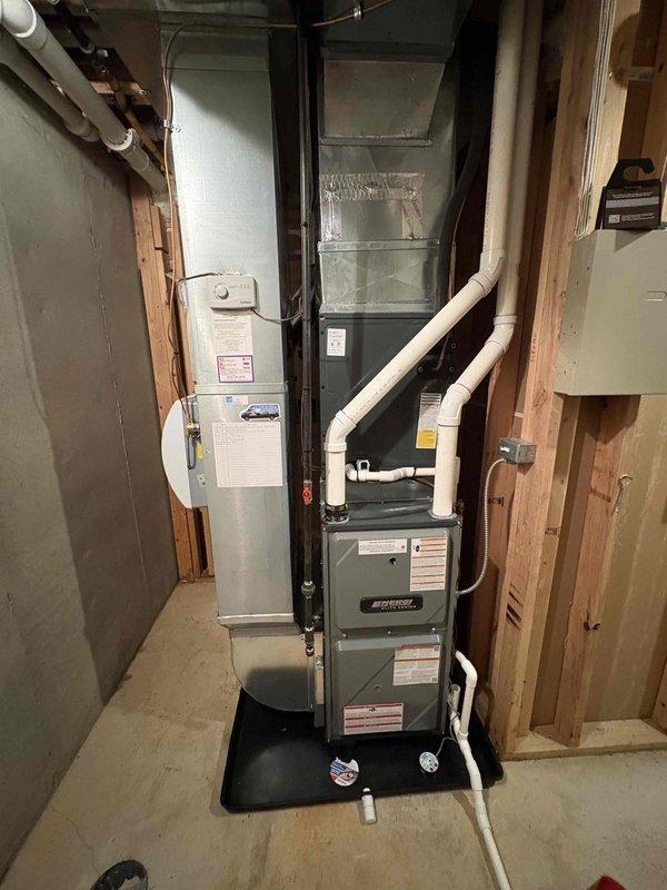 Installed a new Amana Elite Series upflow gas furnace on a drip pan, connecting it to the existing supply plenum and ductwork. Completed PVC combustion air/exhaust venting, condensate drain line, gas piping with shutoff, and electrical connections. Reinstalled the humidifier and thermostat control, and applied all required warning and instruction labels.