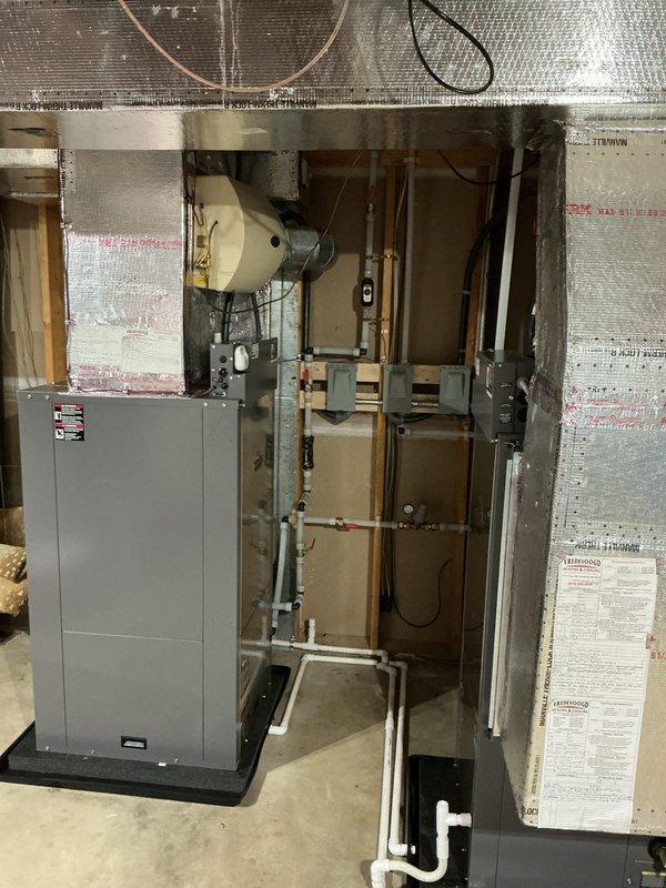 Installed a new geothermal heat pump system in the basement mechanical area, including a vertical air handler on a vibration-isolation pad with insulated supply plenum and ductwork connections. Completed the PVC loop piping with isolation valves, pressure gauges, and fittings, and mounted and wired the associated electrical disconnects and controls. System was left clean, properly secured, and free of visible leaks or damage.