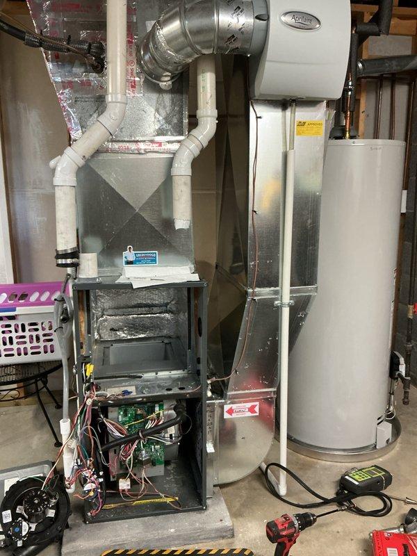 Performed annual heating maintenance on a gas furnace, including removal of lower access panels, inspection of the control board, wiring, inducer/blower assembly, and PVC vent and condensate piping, along with testing of system operation using a digital gauge. Inspected the Aprilaire humidifier on the supply plenum and noted discoloration and residue along a bolted panel seam in the heat exchanger section, which warrants monitoring for corrosion or leakage. No frost, rust, or ice buildup was observed on surrounding components.