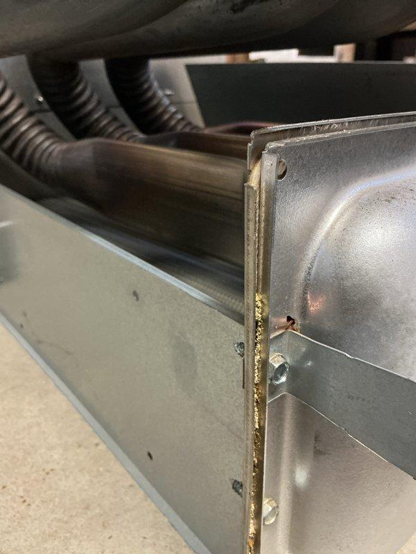 Performed annual heating maintenance on a gas furnace, including removal of lower access panels, inspection of the control board, wiring, inducer/blower assembly, and PVC vent and condensate piping, along with testing of system operation using a digital gauge. Inspected the Aprilaire humidifier on the supply plenum and noted discoloration and residue along a bolted panel seam in the heat exchanger section, which warrants monitoring for corrosion or leakage. No frost, rust, or ice buildup was observed on surrounding components.