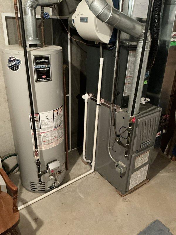 Performed an on-site evaluation of a non-operational 22-year-old Tempstar upright gas furnace with an attached evaporator coil cabinet and an air-exchange unit, and documented the equipment, flue, condensate drain, and gas piping with photos. The furnace was found intact with no visible rust, frost, or damage, though a small amount of airflow was reported coming from the unit while idle, and the system's age warrants replacement consideration. A replacement estimate was presented, and the homeowner is weighing their options.