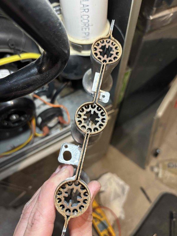 Performed annual heating tune-up on the furnace and humidifier. Inspected the burner assembly and found heavy rust and corrosion on the burner component, indicating deterioration that should be addressed to maintain safe, efficient operation. Serviced the humidifier and replaced the water panel/pad, with the drain pan showing buildup and residue consistent with mineral deposits.