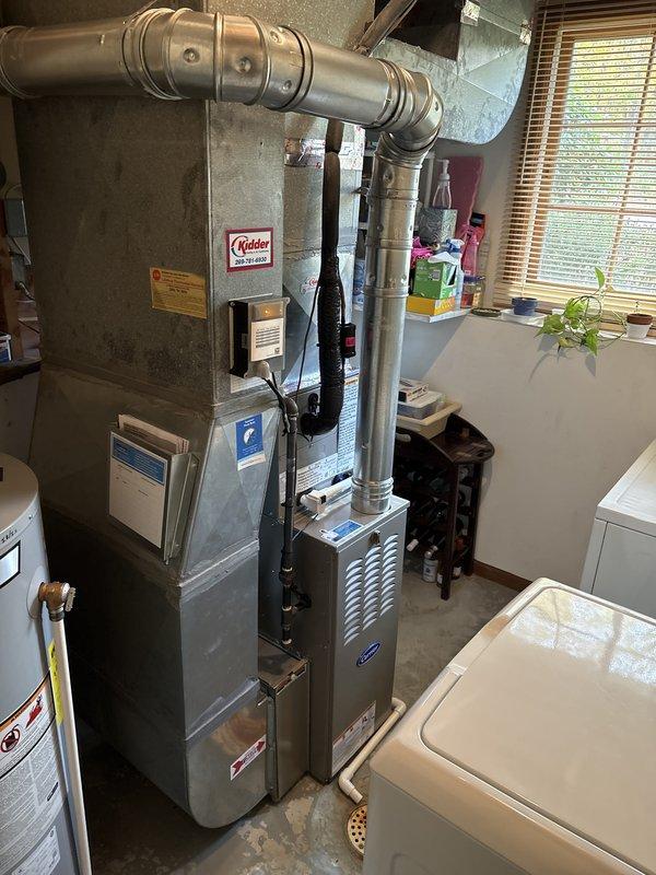 Installed a new upright gas furnace with matching AC components, connecting the supply plenum and ductwork, galvanized flue vent, and gas and electrical supply through flexible conduit to the junction box. Routed and secured the PVC condensate drain piping to the floor drain, and verified all connections, equipment labeling, and system operation, leaving the unit clean with no visible damage.