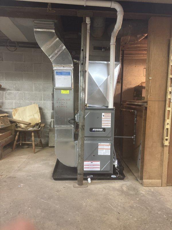 Installed a new Energi Elite Series gas furnace in the basement utility area on a drain pan, connecting the supply and return ductwork, plenum, gas line, and PVC intake/exhaust venting. Verified the furnace is level and secured, labeled the return air filter size (16x24x1 or 16x25x1), and confirmed the adjacent water heater flue remains properly routed and undisturbed.