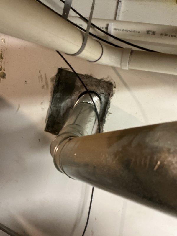 Responded to a reported malfunction on a 9-year-old Rheem Classic Series gas tank water heater and inspected the unit, its gas supply piping and shutoff valve, and the galvanized flue/vent connection at the ceiling penetration. Observed soot staining and debris around the flue opening with a gap between the vent pipe and the ceiling cutout, and noted the surrounding area is cluttered with stored materials near the appliance, which may affect combustion air and clearance; repair options were quoted on site.