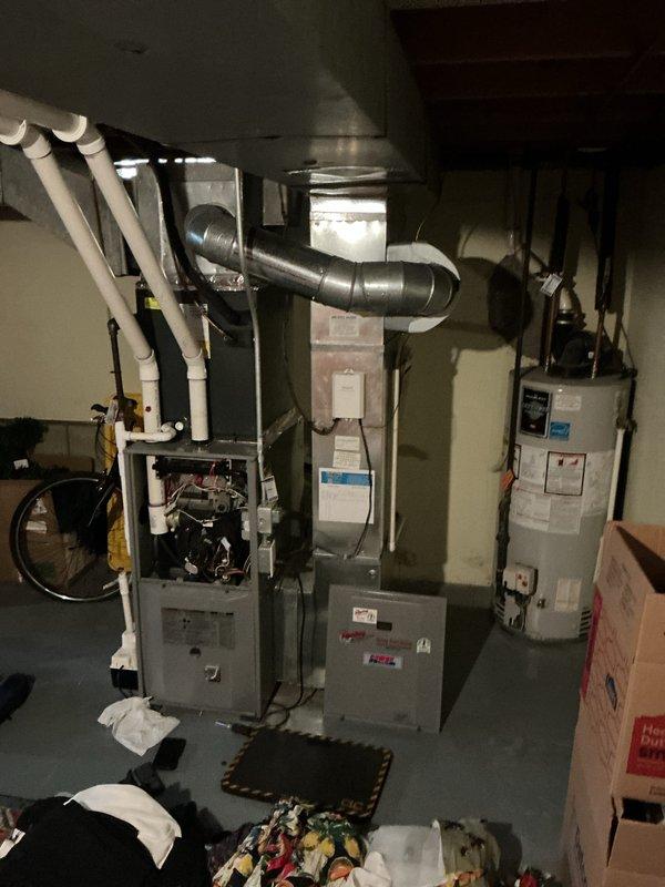 Performed a rental inspection on one gas furnace and one gas water heater, with the furnace access panel removed to visually assess the burners, wiring, blower motor, and control components. Inspected the PVC vent piping, flexible and rigid ductwork, plenum connections, and water heater piping, and found no visible frost, rust, or cracking. Documented equipment condition with photos and noted clutter around the mechanical area.