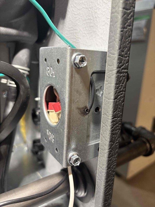 Responded to a no-heat call on a newly installed furnace and AC system with the thermostat displaying a "call for service" message. Inspected the cabinet wiring and found loosely arranged line-voltage conductors at the junction box bracket, including a conductor with nicked insulation and evidence of scorching near the bracket flange. Repaired and secured the damaged wiring and wire-nut connections, restored proper power to the unit, and verified normal operation and thermostat communication.
