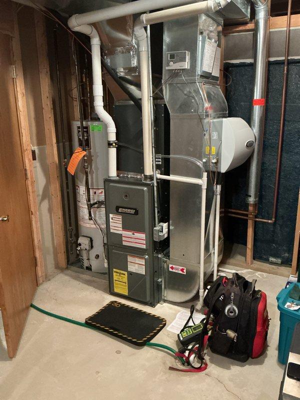 Performed annual heating tune-up on a 14-year-old high-efficiency gas furnace and associated humidifier. During inspection, cracks and holes were identified in the heat exchanger, and a red tag "NOTICE" was affixed to the unit documenting the condition and the unsafe-operation hazard. Furnace and humidifier maintenance were completed per annual service scope, with no frost, rust, or visible external damage noted on the surrounding equipment.