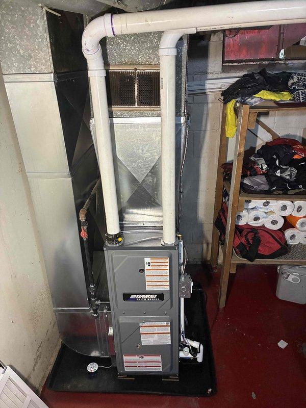 Installed a new Energi Elite Series vertical gas furnace in the basement mechanical area, connecting it to the existing supply plenum and ductwork. Completed PVC condensate drain and combustion venting, copper gas line with shutoff valve, and electrical connections, and set the unit on a drip pan. The installation is complete with no visible leaks or damage.