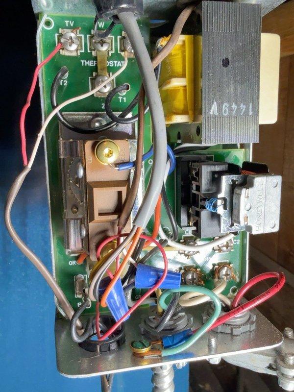 Responded to a no-heat call on a hot water boiler system with two zone circulator pumps and inspected the boiler's control wiring, thermostat terminal connections, and relay/transformer assembly. Dense, tangled wiring and multiple spliced connections were noted in the control box; diagnostic testing was performed with a multimeter to isolate the cause of the loss of heat and verify circuit continuity.