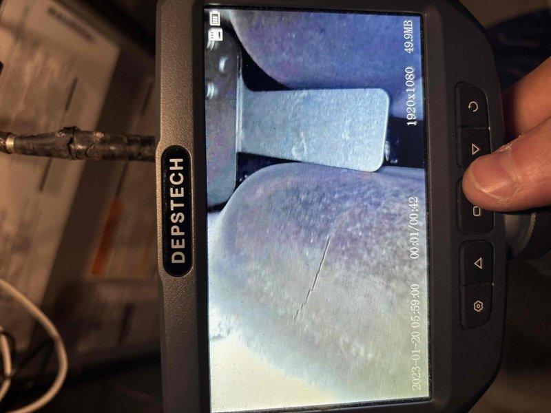 Performed a rental property inspection of one gas furnace and one water heater. Conducted a visual inspection of the furnace, confirming a current municipal mechanical approval sticker, condensate drain piping, and electrical conduit connections. Used a borescope to examine the heat exchanger, which revealed a visible crack or fracture along the tube surface, indicating a potential safety concern that warrants further evaluation or repair.