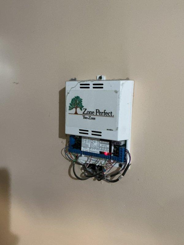 Performed a Furnace Super Tune-up on a 15-year-old furnace as part of routine seasonal maintenance, including inspection of the system's controls and operation. Verified operation of the Bryant thermostat and the Zone Perfect two-zone control panel, noting low-voltage wiring hanging loosely beneath the panel and cracking and discoloration of the panel cover, and recommended securing the wiring and monitoring the panel for future replacement.