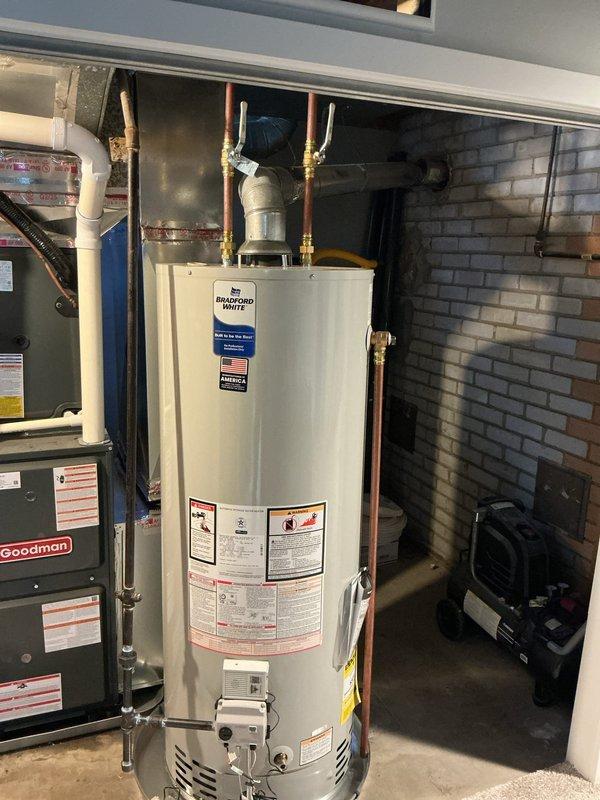Installed a new 50-gallon natural gas, non-direct vent (atmospheric) Bradford White water heater in the existing mechanical closet, positioned on a drain pan. Connected the copper hot and cold supply lines with shutoff valves, reconnected the gas supply line and control valve, and tied the galvanized flue into the existing vent. Verified connections were secure and free of leaks, and the unit was left operational with no visible leaks, rust, or corrosion.