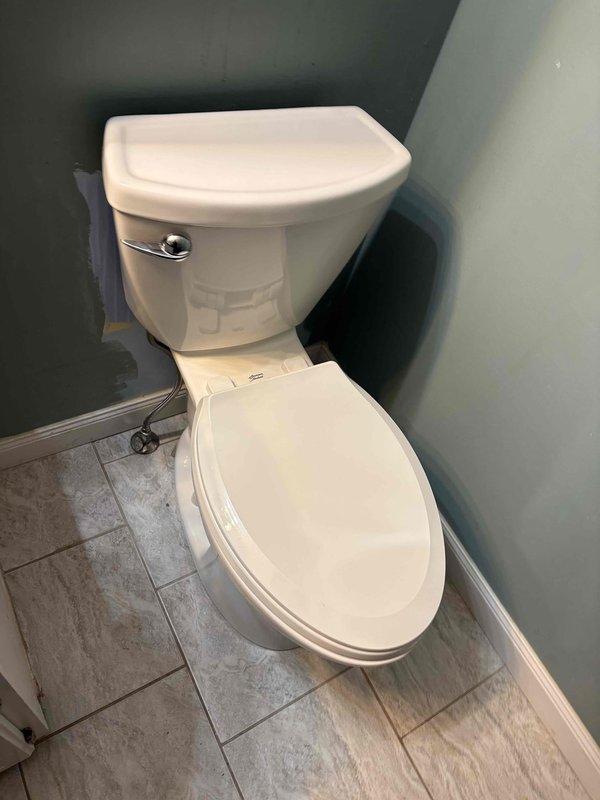 Responded to a leaking toilet. Removed the toilet from the flange, inspected the flange and surrounding tile, and removed the failed wax ring, which was coated in residue and the source of the leak. Cleaned the flange and floor area, then reset the toilet on a new wax ring and reconnected the braided supply line to the angle stop to restore a watertight seal.