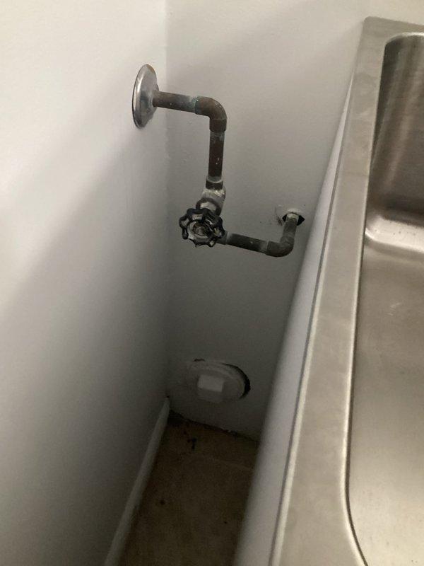 Performed an on-site plumbing estimate for relocating the washer, dryer, and laundry sink to a different area of the laundry room. Inspected the existing water supply piping and shutoff valve, noting oxidation and tarnish at the joints, along with the sink drain assembly, P-trap, and horizontal drain line under the laundry sink, which showed no visible leaks or corrosion. Documented existing conditions with photos to scope the water line, drain, and any gas line relocation required for the new layout.