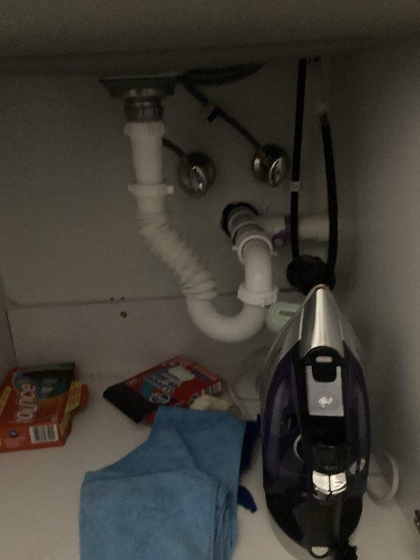 Performed an on-site plumbing estimate for relocating the washer, dryer, and laundry sink to a different area of the laundry room. Inspected the existing water supply piping and shutoff valve, noting oxidation and tarnish at the joints, along with the sink drain assembly, P-trap, and horizontal drain line under the laundry sink, which showed no visible leaks or corrosion. Documented existing conditions with photos to scope the water line, drain, and any gas line relocation required for the new layout.