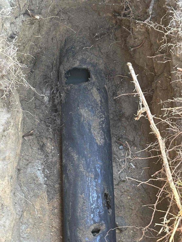 Excavated the affected section of buried drain line adjacent to the foundation, exposing a corroded black pipe with multiple holes and deteriorated sections. Performed an underground spot repair by removing the damaged pipe segments and installing new pipe with proper connections, restoring watertight flow. Backfilled the trench and restored the work area.