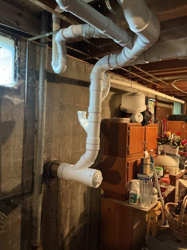 Repiped the basement drain line using new white PVC with fitted elbows, couplings, and a wye, and connected it to the existing galvanized drain with a secured rubber transition coupling and band clamps. Installed a pump-in-a-box system, routing the discharge through the foundation wall, and completed the work over a 1.5-day period.