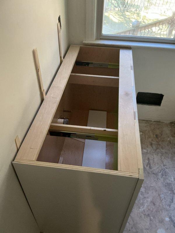 Assessed the renovation area for reconnection of the toilet, sinks, and shower fixtures. Site is currently unfinished, with bare OSB subflooring, patched drywall, and an uncountered base cabinet in place. Fixture reconnection will proceed once finishes and cabinetry are complete.