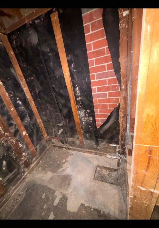 Performed an on-site plumbing estimate for an owner-occupied single-family home undergoing a bathroom remodel, assessing the gutted space with exposed wall framing, existing copper supply stubs with shut-off valves, a floor drain access pocket, and the in-place toilet. Documented existing rough-in conditions and photographed the work area to determine the scope of plumbing modifications and fixture installation required.