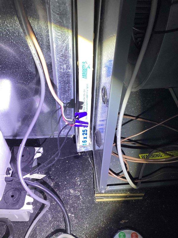 Responded to a no-heat call on a nine-year-old EnergiAir furnace with no power after a reported spark during air filter cover removal. Inspected the filter cabinet and surrounding low-voltage and line-voltage wiring, where photos show wire-nut splices and conductors routed near the filter slot, and checked for shorted or damaged conductors and blown protection. Restored power to the unit and verified normal furnace operation.