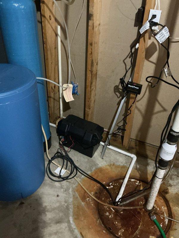 Installed a new Liberty Pumps sump pump with a battery backup system, including a battery box, control unit, and associated wiring. Connected the discharge piping with a check valve and rubber couplings, and tagged the electrical cords for identification. The system was set up at the existing sump pit to provide primary and backup water removal during power outages.