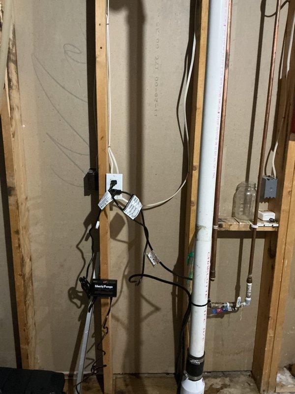 Installed a new Liberty Pumps sump pump with a battery backup system, including a battery box, control unit, and associated wiring. Connected the discharge piping with a check valve and rubber couplings, and tagged the electrical cords for identification. The system was set up at the existing sump pit to provide primary and backup water removal during power outages.