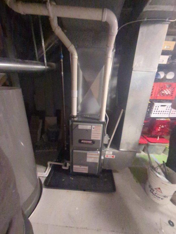 Installed a new vertical gas furnace on a drip pan, with PVC combustion venting routed to the ceiling and condensate drain piping connected to the floor drain. Connected the supply plenum and galvanized ductwork to the existing duct system, completing the equipment installation with all unit labels and warning stickers in place. Visual inspection showed a clean, secure installation with no damage, rust, or leaks.