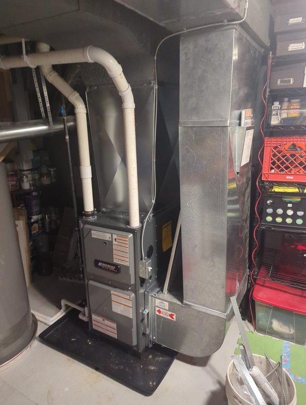 Installed a new vertical gas furnace on a drip pan, with PVC combustion venting routed to the ceiling and condensate drain piping connected to the floor drain. Connected the supply plenum and galvanized ductwork to the existing duct system, completing the equipment installation with all unit labels and warning stickers in place. Visual inspection showed a clean, secure installation with no damage, rust, or leaks.