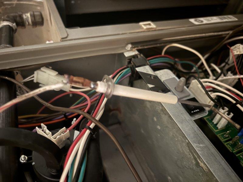 Performed a furnace super tune-up, inspecting the cabinet interior, wiring harness, flame sensor/igniter, and control board connections and finding no wiring damage. Observed corrosion and rust staining on the cabinet wall near the inducer motor, indicating past moisture exposure, along with a heavily textured, corroded-looking run capacitor that should be tested and monitored for replacement. Cleaned accumulated dust and debris from the components and verified system operation.