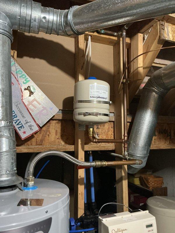 Inspected the AO Smith water heater for a recurring leak and checked the thermal expansion tank, copper supply piping, shutoff valve, and braided stainless flexible connectors for moisture, corrosion, and fitting integrity. No active leaks, rust, or visible damage were found at the connections, tank, or venting, and the system was left operating normally.