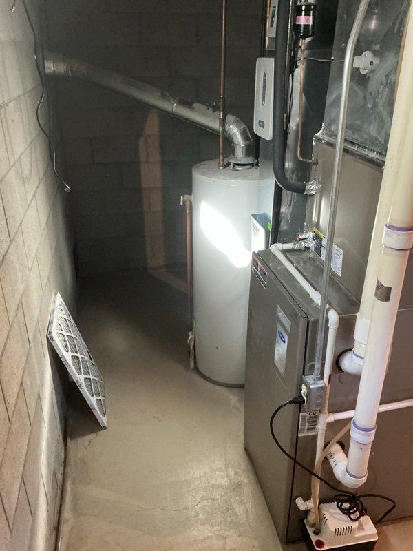 Performed an on-site estimate for furnace replacement following a prior diagnosis of a failed inducer motor. Inspected the existing high-efficiency condensing furnace, condensate pump and PVC drain line, refrigerant line set, and galvanized vent/flue penetration through the masonry wall, and documented equipment condition and installation conditions with photos to support replacement options.