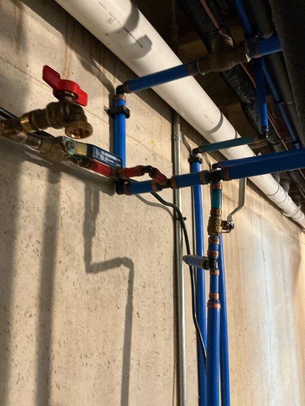 Inspected the A.O. Smith ProLine XE water heater following a reported leak and found moisture pooled on the floor beneath and in front of the unit. Evaluated the connected PEX supply lines, valves, and fittings, along with the tank, to isolate the source of the leak and determine whether the expansion (bladder) tank was a contributing factor.