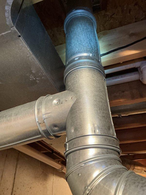 Performed an on-site estimate for replacement of an aging (15+ year) Rheem tank-style water heater located in a utility area with standing water present on the floor. Inspected the water heater, flue, shutoff valves, and adjacent water softener and ductwork, and documented existing conditions and equipment data labels with photographs to support replacement quoting.
