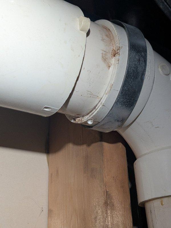 Performed annual heating tune-up on 12-year-old Rheem furnace with humidifier, including inspection of combustion components, humidifier, and condensate drain system. Documented rust staining at the PVC exhaust/drain coupling connection and debris with moisture staining on the concrete floor beneath the equipment, indicating past leakage; recommend monitoring the coupling and surrounding area for further moisture and cleaning the debris from the floor.
