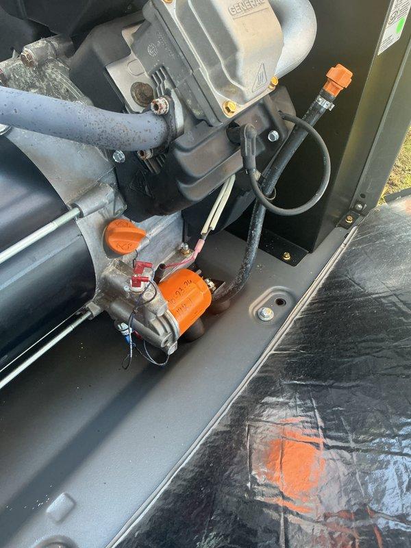 Performed annual preventive maintenance tune-up on a Honeywell standby generator, inspecting the engine compartment, wiring, hoses, exhaust, and control panel. All components were found clean and in good condition, with no visible rust, leaks, or damage. The unit was left operational with no deficiencies noted.