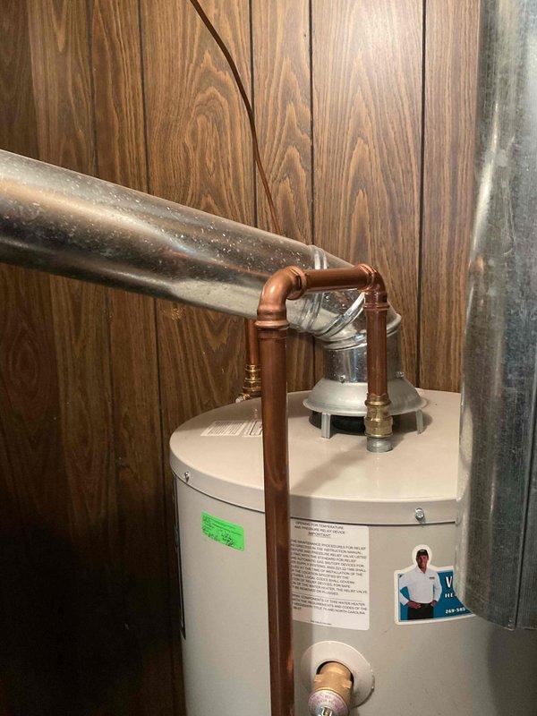 Installed dielectric unions on the water heater's inlet and outlet connections and replaced the anode rod to protect the tank from corrosion. New copper supply piping with brass fittings was run to the top of the tank, and the connections were left clean and properly secured.